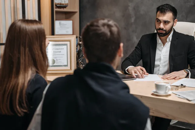 A lawyer in an elegant office meeting with clients, discussing documents. UK GDPR and PECR for London creator campaigns
