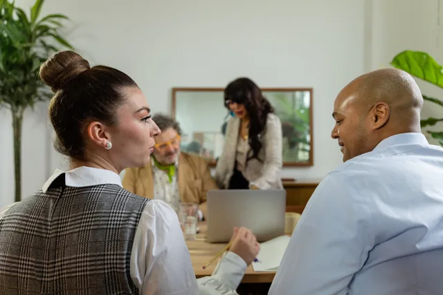 Engaged office team in business discussion around a laptop, fostering collaboration. How to read talent agencies demand signals before hiring