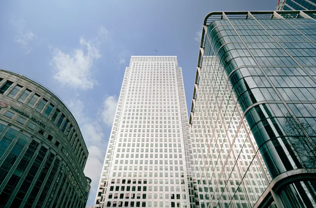 Low-angle view of iconic skyscrapers in London's bustling business hub with blue sky background. Talent management market sizing in England: an ONS method