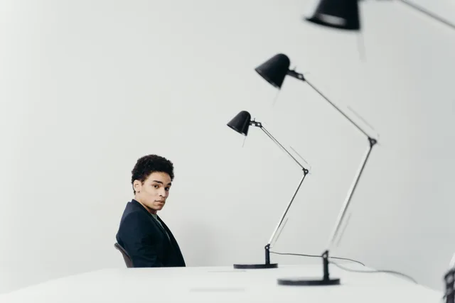 Young man in modern office setting with sleek lamps and minimal design. Why talent agencies measurement and reporting needs a 2027 rethink