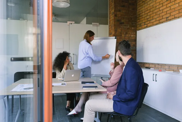 Concentrated colleagues sitting at table in modern workplace and discussing details of project during meeting in daytime. Why talent management rollouts stall after agency demos